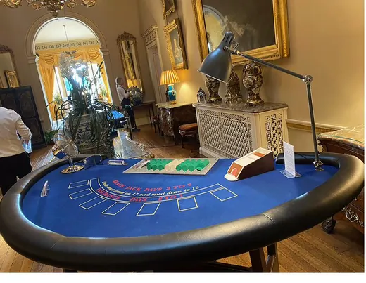 Blackjack table set up beneath a chandelier in a grand function room