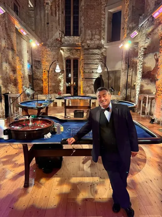 Croupier with roulette and blackjack tables in a historic hall